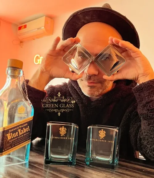 Lanchi, founder of Green Glass, with bespoke glass coasters handcrafted from upcycled Johnnie Walker Blue Label whisky bottles.